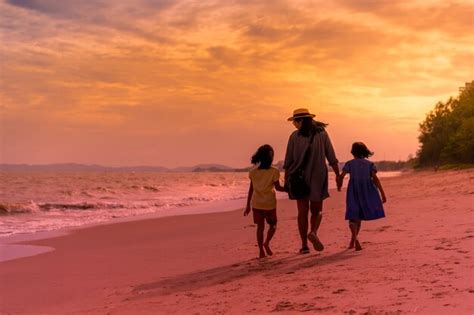 Madre Con Dos Hijas Caminando En La Playa En El Atardecer O El Amanecer