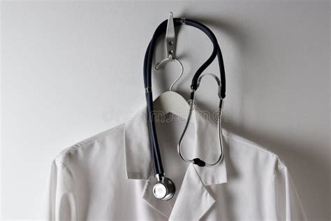Closeup Doctors White Lab Coat Hanging On A Hook With Stethoscope