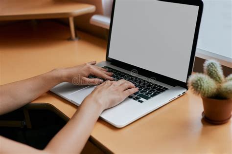 Woman Typing On Her White Laptop Computer At Working Desk Stock Photo