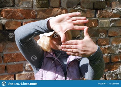 A Girl Near A Brick Wall With Her Hands Imagines A Camera St Veronica