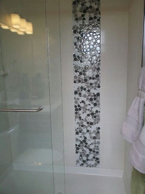 A Bathroom With A Glass Shower Door Next To A Towel Rack