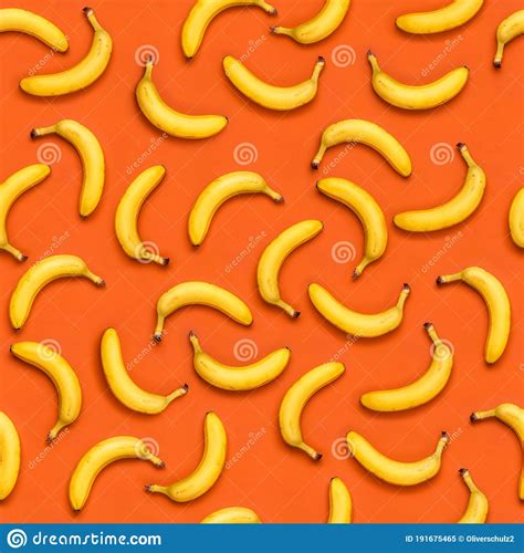 Seamless Banana Pattern With Random Oriented Banana Fruits On Orange