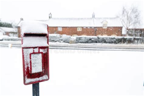 A Red British Post Box Covered In Snow In A Wintery Snow Covered