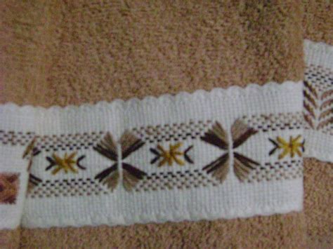 este es el bordado yugoslavo de una de las toallitas faciales en tono café claro toallas