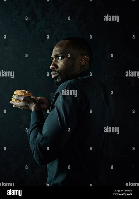 El Joven Hombre Afroamericano Comer Una Hamburguesa Y Apartar La Mirada