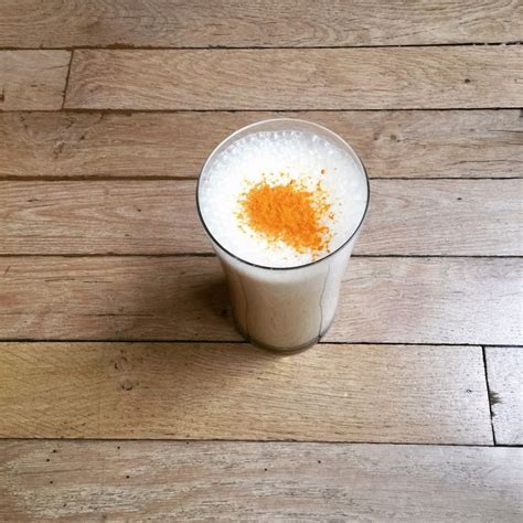 A Drink With Orange Sprinkles Sitting On Top Of A Wooden Floor
