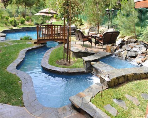 Small Backyard Lazy River Pool Design With Stone Liner And Lounge Area Beside Stone Waterfall