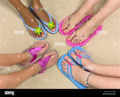 Four Pairs Of Girls Feet In Circle All Wearing Colourful Flip Flops