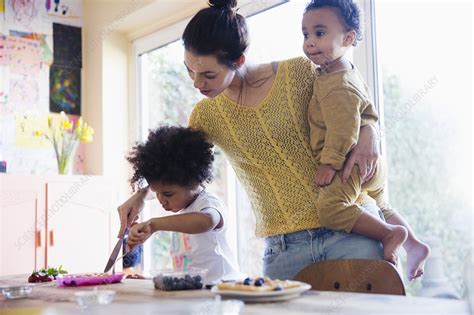 Mother Helping Toddler Daughter Cutting Waffles Stock Image F022
