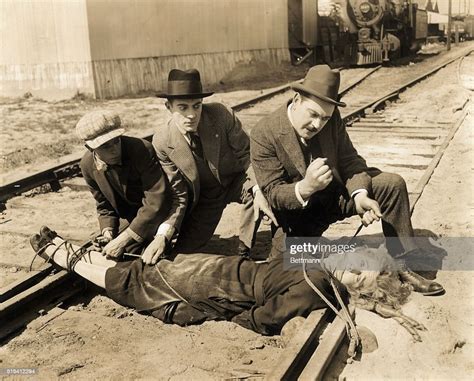 Actors Hugh Fay And Charles Arling Tie Louella Maxam To A Railroad