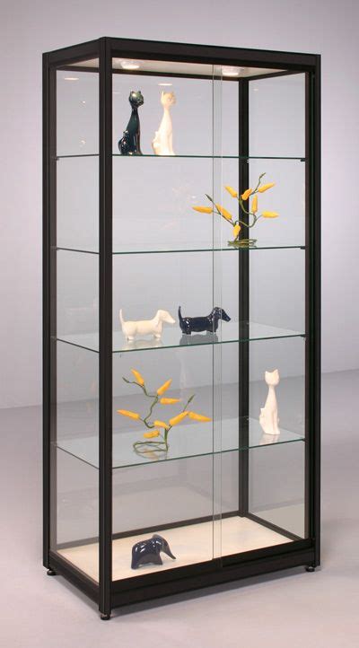 A Glass Display Case Filled With Different Types Of Figurines And Cats
