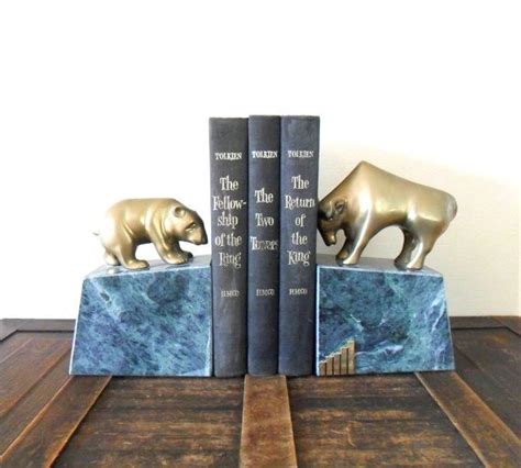 Two Bookends With Bears On Them Sitting On Top Of A Wooden Table Next