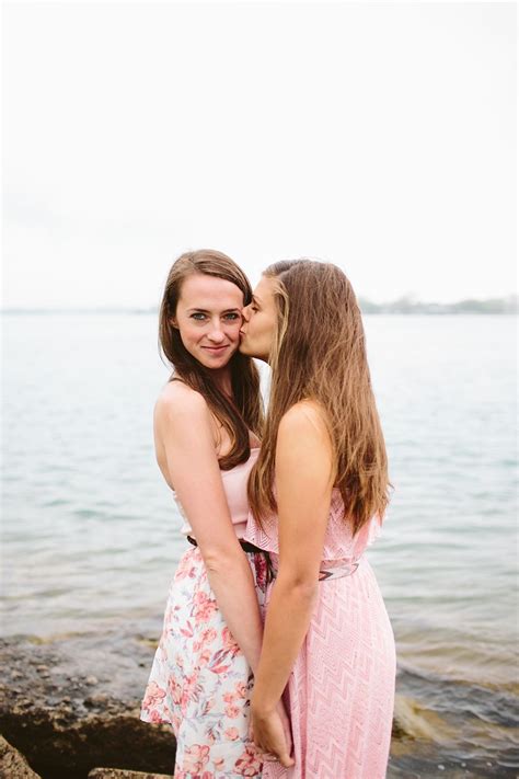Two Women Standing Next To Each Other In Front Of The Ocean With Their
