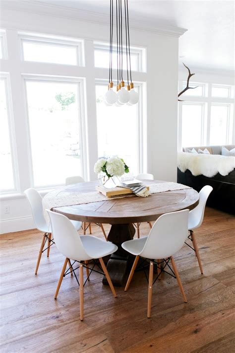 Create a cozy reading nook or dining area for littles ones! A rustic round wood table surrounded by white Eames dining ...