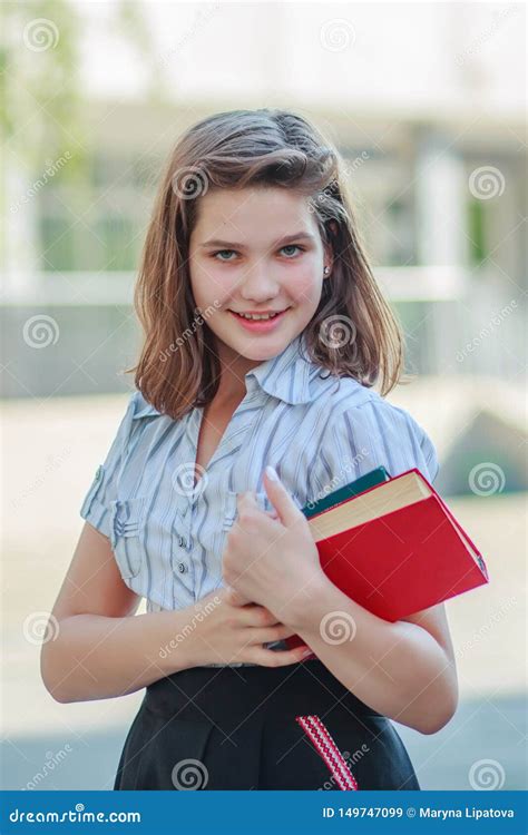Beautiful Schoolgirl Teen Holds Textbooks Pupil In Front Of School In
