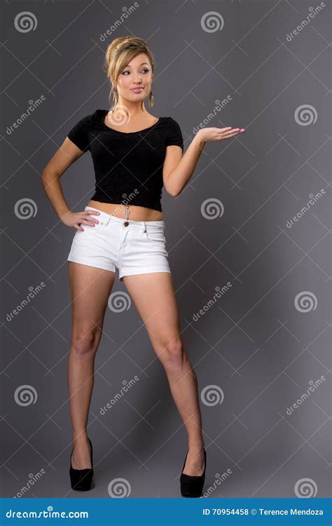Portrait Of Cute Young Blonde In White Shorts And Dark Top On G Stock