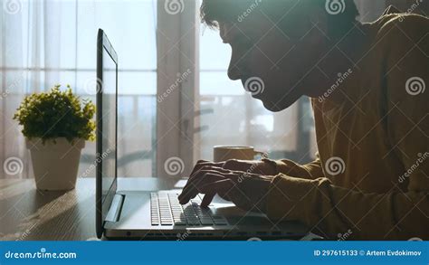 Focused Concentrated Young Man Typing On Keyboard While Working On