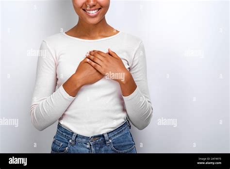 cropping image of cute mulatto woman shows a love gently gesture with her arms on her chest