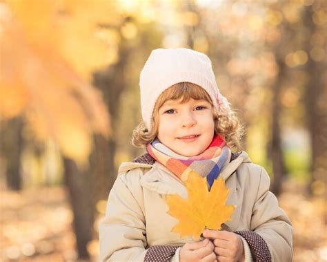 Premium Photo Happy Child With Maple Leaf In Autumn Park Against