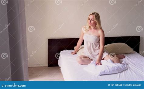 Beautiful Blonde Woman Wakes Up After Sleep In The Bedroom On The Bed