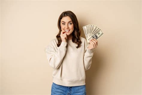 Excited Brunette Woman Holding Money And Biting Finger With Yearning Face Watns To Buy Smth