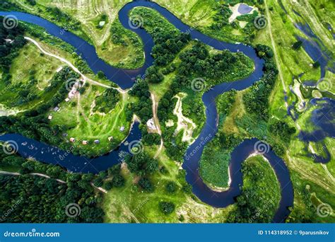 Top View Of The Valley Of A Meandering River Among Green Fields Stock