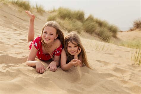 Porträt Von Zwei Lächelnden Mädchen Liegen Am Strand Lizenzfreies