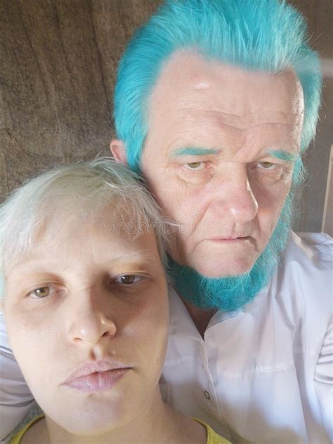 Äldre män med blått skägg och grått hår står bredvid varandra och filmar sig på telefon
