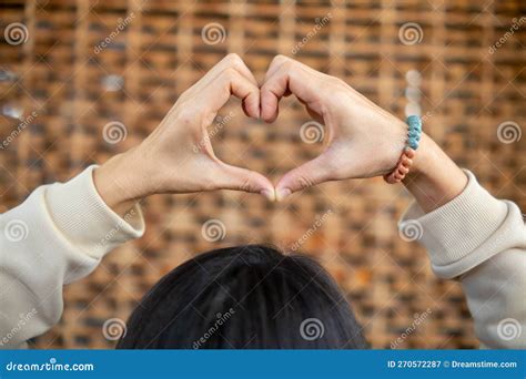 Young Woman Shows Her Hands Above Her Head Making Heart Symbol To Show Friendship Love And