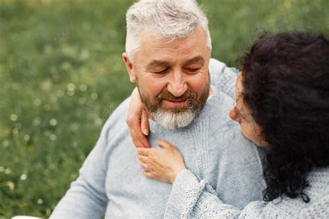 Senior Couple Sitting In A Park And Looking On Each Other Stock Image