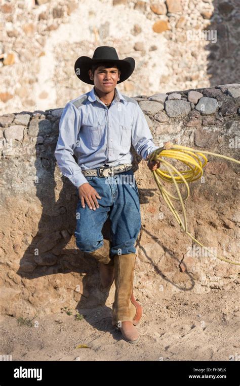 A Mexican Charro Or Cowboy Poses In Cowboy Hat And Lasso At A Stock