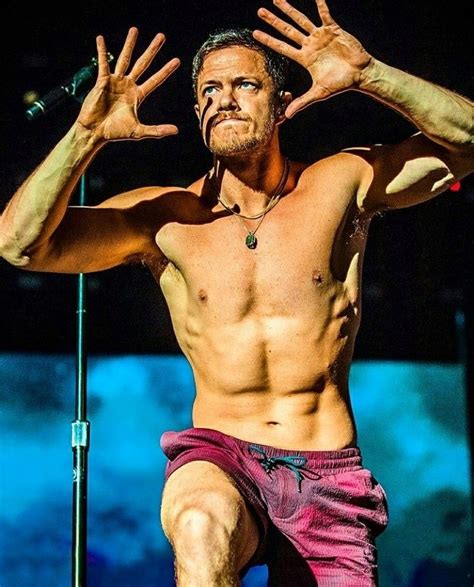 A Shirtless Man On Stage With His Hands In The Air