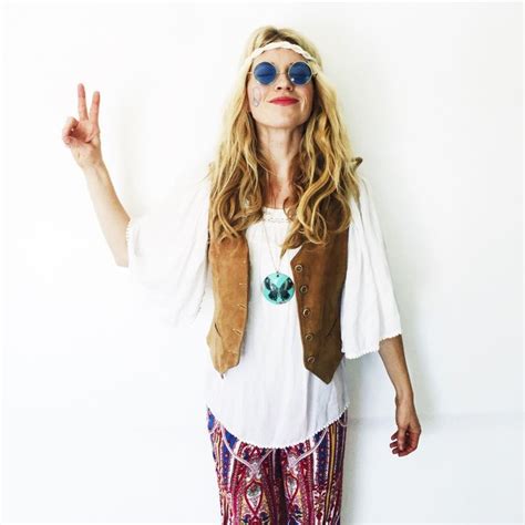 A Woman Wearing Sunglasses And A Vest Making The Peace Sign With Her