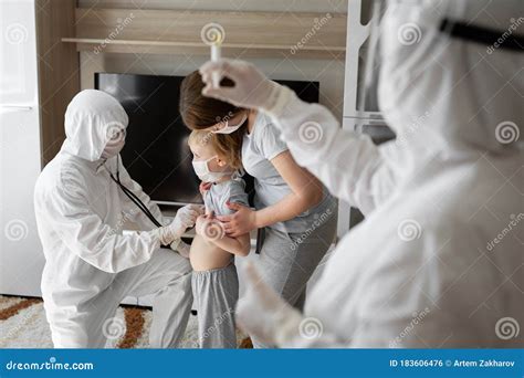 Pediatrician Doctor Examining Sick Child In Face Mask And A Protective