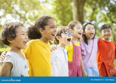 Multiethnic Group Of School Kids Laughing And Embracing Stock Photo
