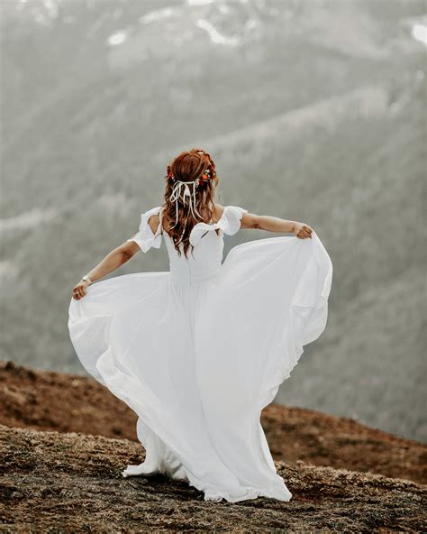 Back View Photo Of Woman In White Dress Standing On Brown Field · Free