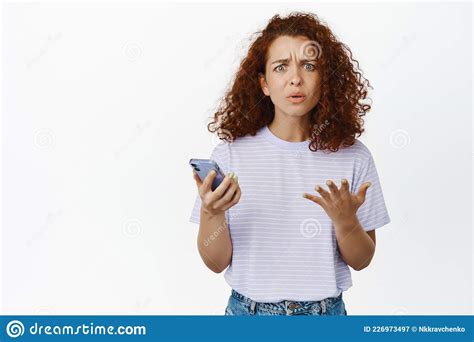Confused Redhead Girl Looking Puzzled Holding Smartphone Cant Understand Smth On Phone