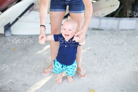 Baby Not Happy Holding On To Moms Hands Stock Photo Download Image