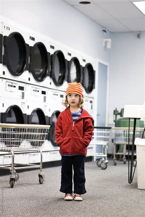 Boy Stands Alone In Laundromat By Stocksy Contributor Cara Dolan