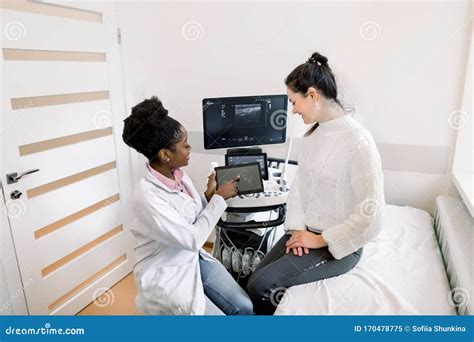 African Female Doctor Gynecologist Showing Echo Ultrasound Photo On
