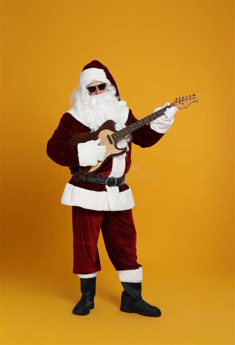 Santa Claus Playing Electric Guitar On Yellow Background Christmas