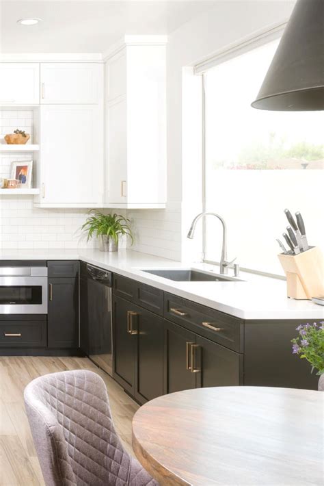 Black shaker kitchen cabinets adorned with vintage brass hardware and a white quartz countertop fixed against white brick stacked tiles. Black and white shaker cabinets paired with gold hardware. Open shelving, white counter tops ...