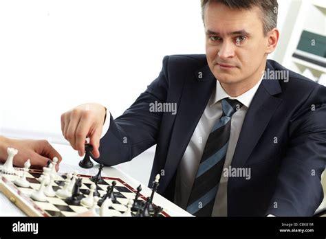 Image Of Successful Businessman Looking At Camera While Playing Chess