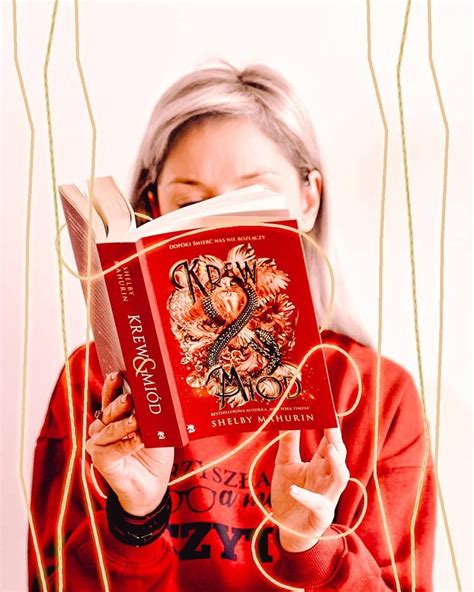 A Woman Holding A Red Book In Front Of Her Face