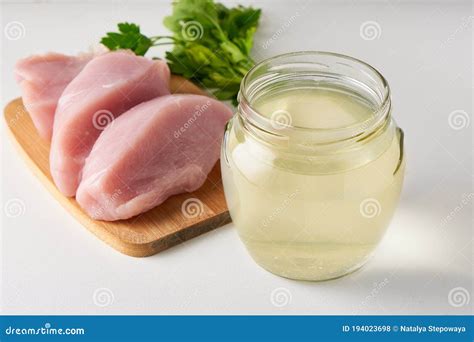 Fresh Poultry Broth In A Glass Jar On A Table With Vegetables And