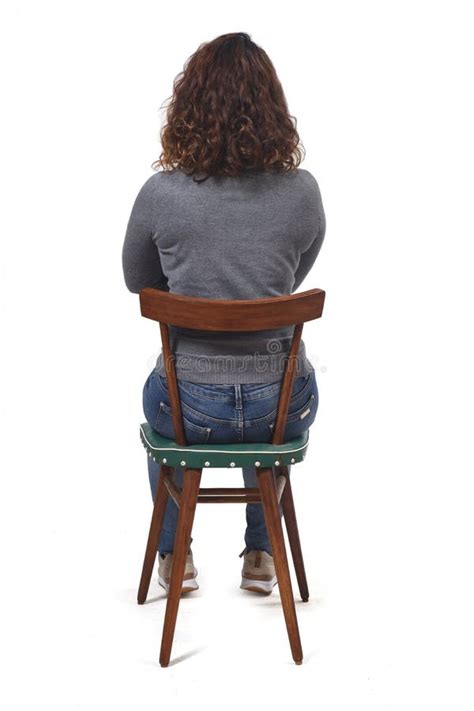Rear View Of A Woman Sitting On Chair On White Background Arms Crossed