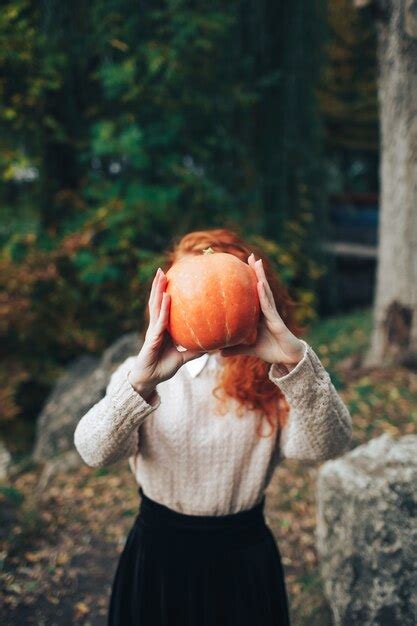Premium Photo Redhead Girl Holding Pumpkin In Autumn Park