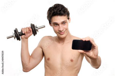 skinny man taking a selfie with his phone while training his bicep muscle beautiful teenager