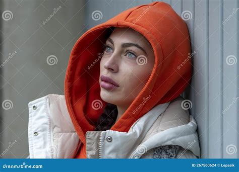 A Beautiful 25 30 Year Old Woman In An Orange Hood On A Neutral Light