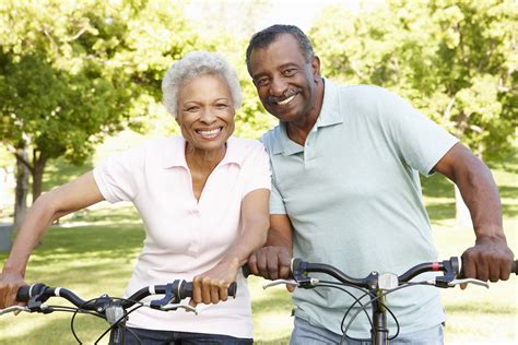 Senior African American Couple Cycling In Park Aw Health Care